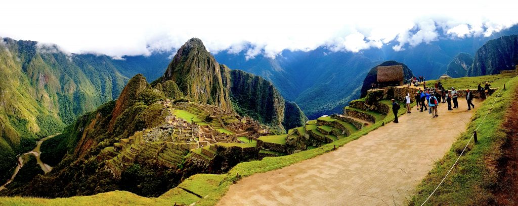 A Landscape Image of Machu Picchu with tourists taking photos. 