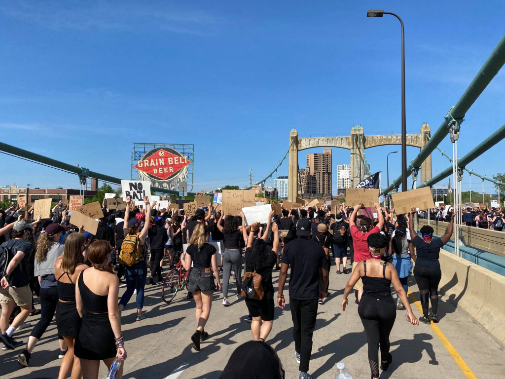 A group of people walking down the street in front of a crowd

Description automatically generated